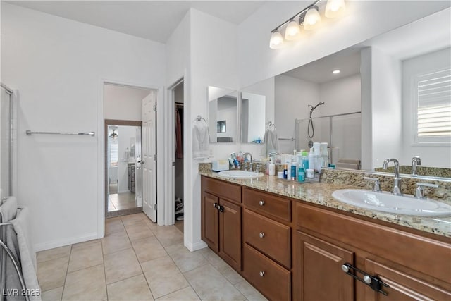 full bathroom with double vanity, tile patterned flooring, walk in shower, and a sink