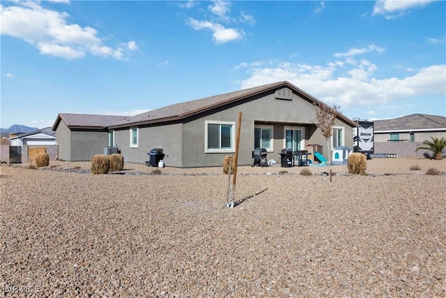 back of property featuring a patio area and stucco siding