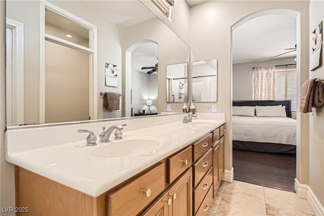 ensuite bathroom with a ceiling fan, double vanity, a sink, and ensuite bathroom