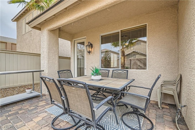 view of patio with outdoor dining space and fence