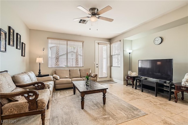 living room featuring light tile patterned floors, ceiling fan, visible vents, and baseboards