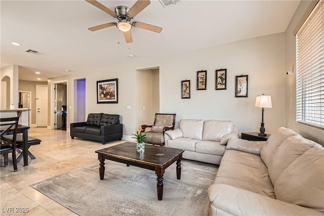 living room featuring arched walkways, recessed lighting, visible vents, a ceiling fan, and baseboards