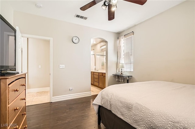 bedroom featuring baseboards, visible vents, arched walkways, ceiling fan, and dark wood-type flooring