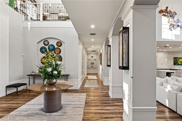 hall with baseboards, visible vents, wood finished floors, stairs, and recessed lighting