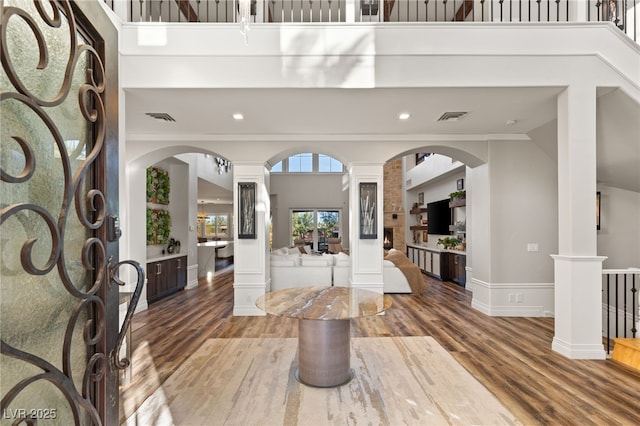 foyer featuring decorative columns, visible vents, and arched walkways