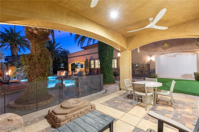 view of patio / terrace featuring ceiling fan, outdoor dining area, fence, and a fenced in pool