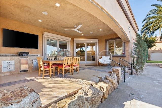 view of patio with ceiling fan, outdoor dining area, and an outdoor kitchen