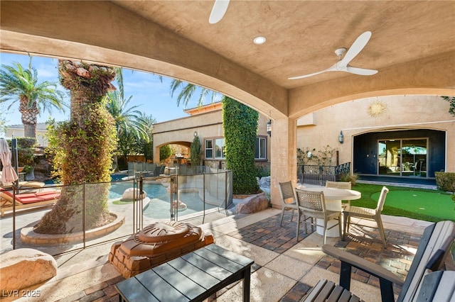 view of patio with an outdoor pool and a ceiling fan