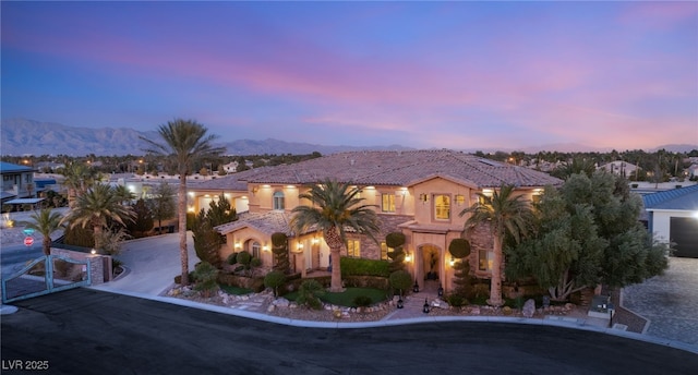 view of front of home with driveway, a tile roof, a mountain view, and stucco siding