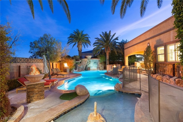 view of pool featuring a fenced in pool, a patio area, fence, and a fire pit