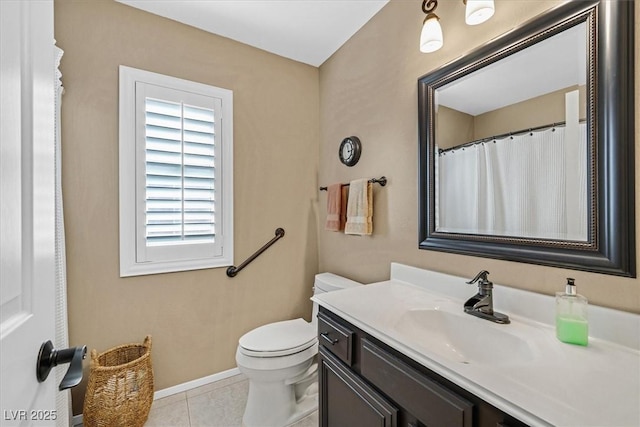 bathroom featuring toilet, baseboards, vanity, and tile patterned floors