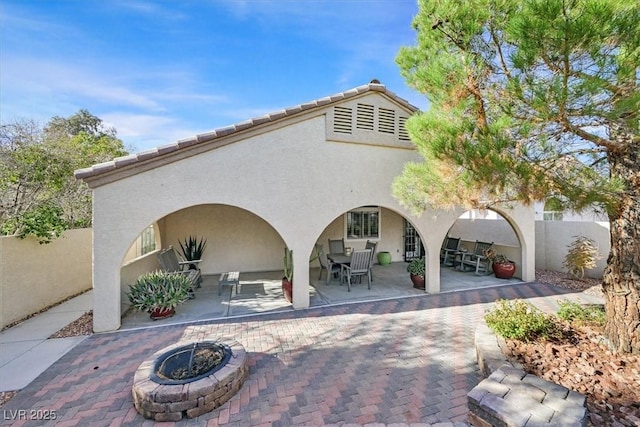 surrounding community featuring a patio area, an outdoor fire pit, and fence