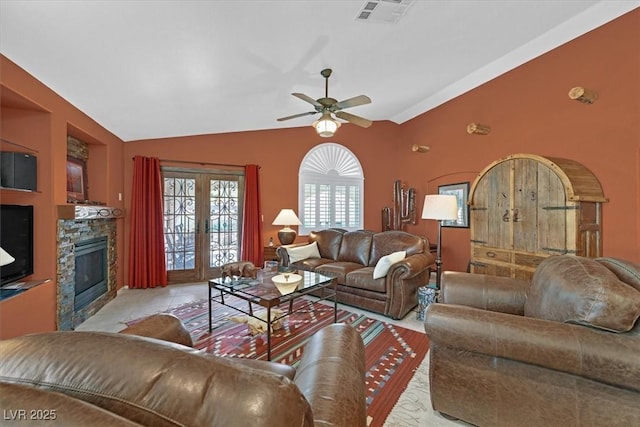 living room with vaulted ceiling, french doors, a fireplace, and visible vents