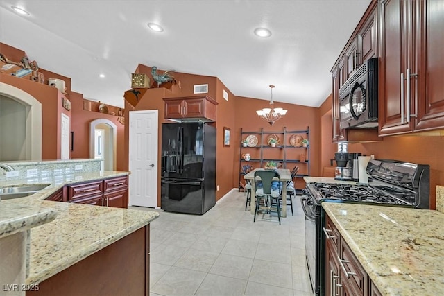 kitchen with visible vents, vaulted ceiling, black appliances, a chandelier, and a sink