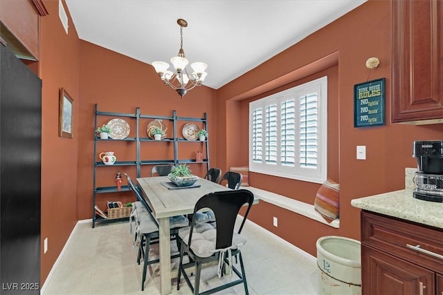 dining room featuring light tile patterned floors, baseboards, and a notable chandelier