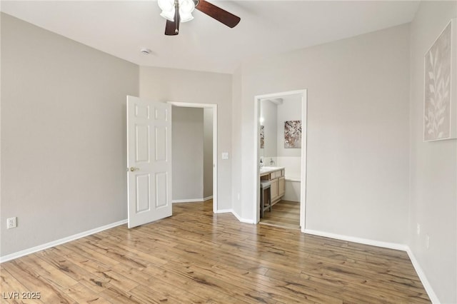 unfurnished bedroom featuring ceiling fan, light wood-type flooring, baseboards, and connected bathroom