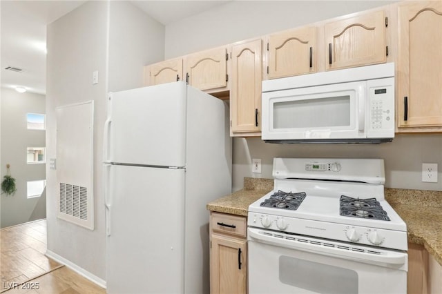 kitchen featuring visible vents, light brown cabinetry, light countertops, light wood-style floors, and white appliances