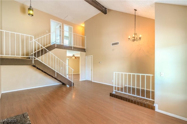 interior space with stairs, beamed ceiling, wood finished floors, and visible vents