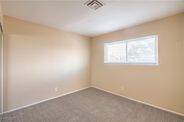 spare room with visible vents, carpet floors, and baseboards