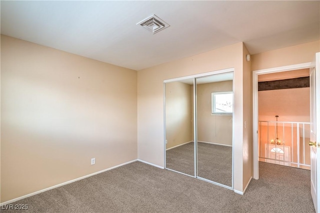 unfurnished bedroom with a closet, baseboards, visible vents, and carpet floors