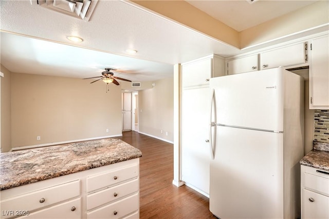 kitchen featuring visible vents, dark wood finished floors, white cabinetry, freestanding refrigerator, and ceiling fan