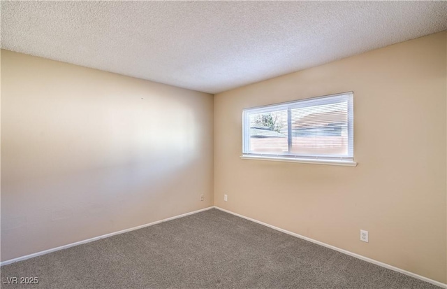 carpeted spare room featuring baseboards and a textured ceiling