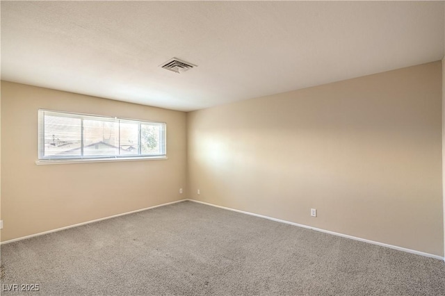 carpeted spare room with baseboards and visible vents