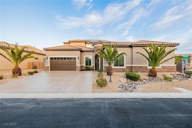 mediterranean / spanish-style house featuring an attached garage, stone siding, driveway, and stucco siding