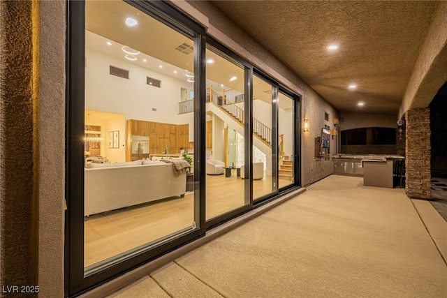 view of patio / terrace with exterior kitchen, visible vents, and a balcony