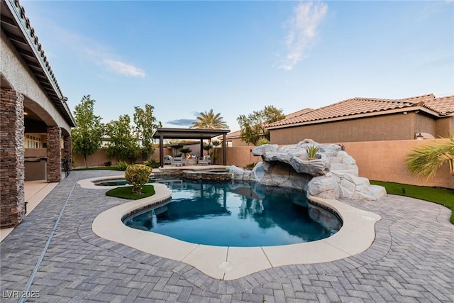 view of swimming pool with a gazebo, exterior kitchen, a patio area, and a fenced backyard