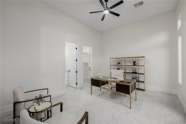 carpeted office space featuring baseboards, visible vents, and a ceiling fan