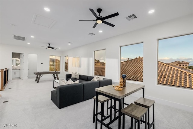 living area with attic access, recessed lighting, visible vents, and light carpet