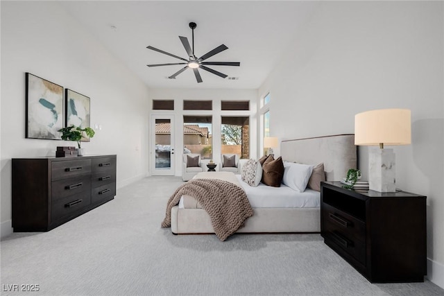 bedroom featuring ceiling fan, a high ceiling, light colored carpet, and access to exterior