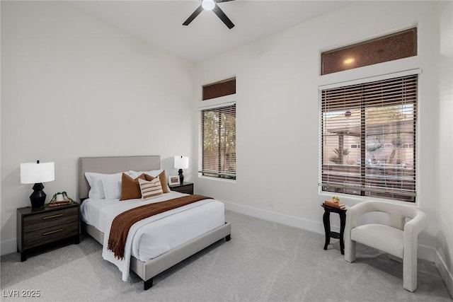 bedroom with a ceiling fan, light colored carpet, and baseboards