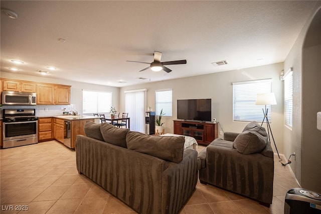 living room featuring a ceiling fan, light tile patterned flooring, and visible vents