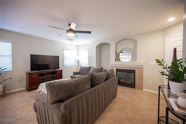 living room with baseboards, visible vents, a tiled fireplace, and light tile patterned flooring