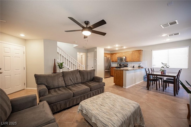 living area featuring light tile patterned floors, stairs, visible vents, and recessed lighting