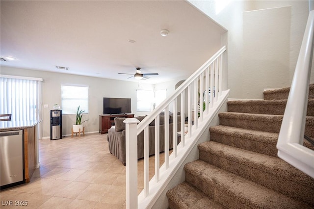 staircase featuring baseboards, tile patterned flooring, visible vents, and a ceiling fan