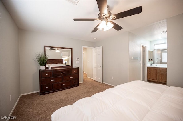 bedroom with carpet floors, ensuite bathroom, a ceiling fan, a sink, and baseboards