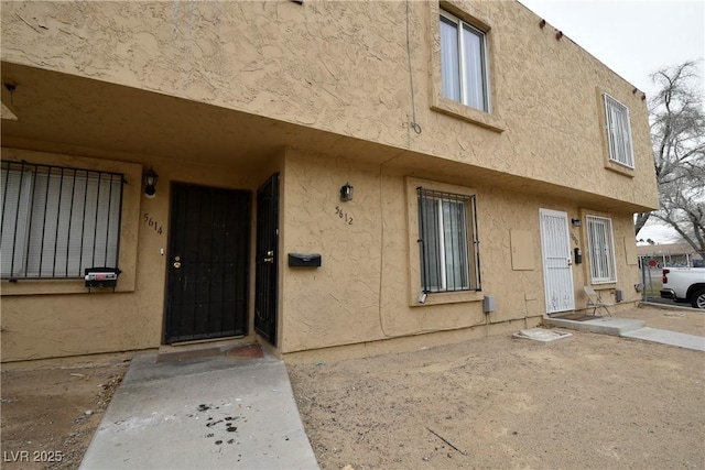 entrance to property featuring stucco siding