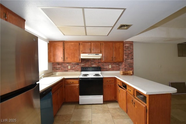 kitchen with electric range, freestanding refrigerator, a peninsula, under cabinet range hood, and dishwashing machine