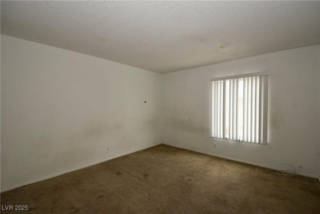 carpeted empty room with a textured ceiling