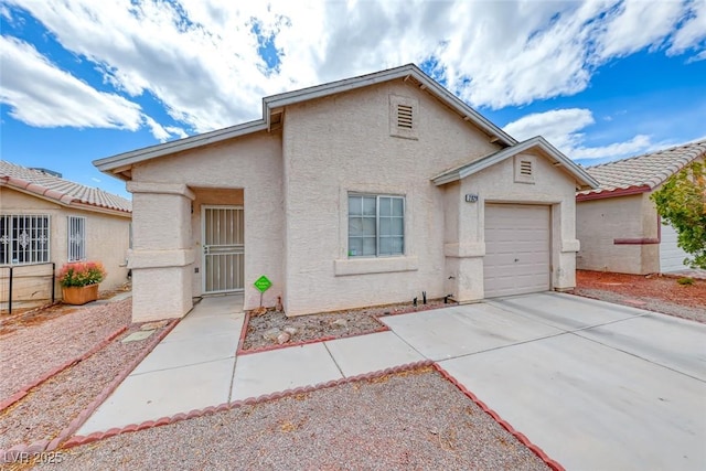 view of front of home featuring a garage, driveway, and stucco siding