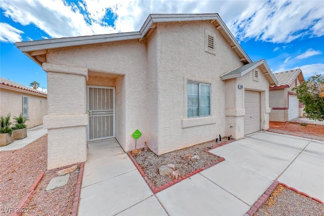 view of front of house with an attached garage, driveway, and stucco siding