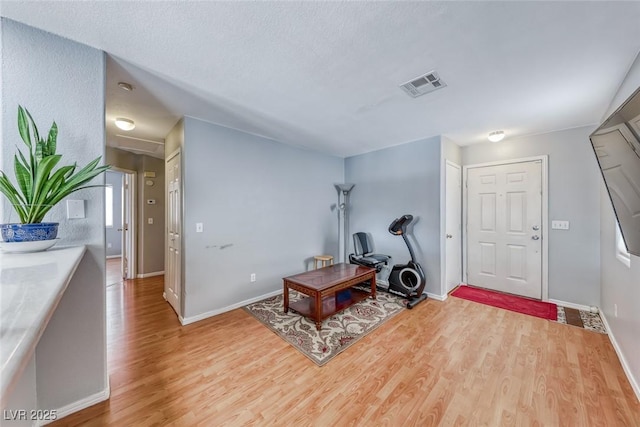 entrance foyer featuring light wood finished floors, visible vents, and baseboards