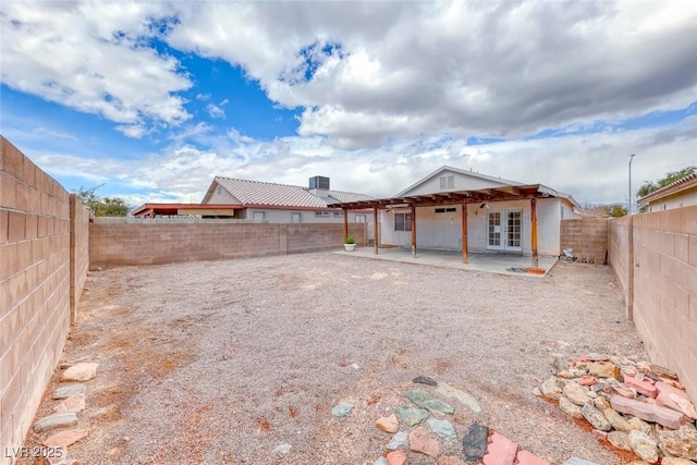 rear view of property with french doors, a patio area, and a fenced backyard