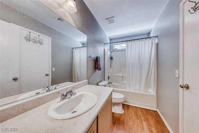 bathroom featuring toilet, vanity, wood finished floors, and visible vents