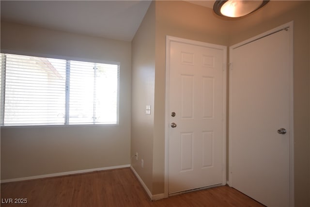 entrance foyer featuring baseboards and wood finished floors