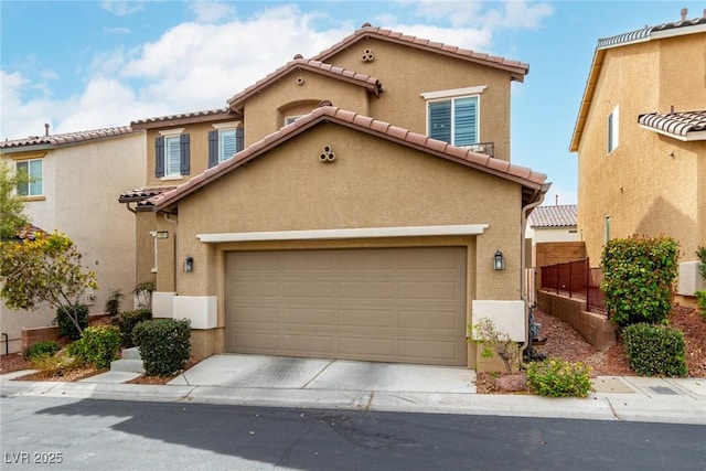 mediterranean / spanish home with driveway, a tile roof, fence, and stucco siding