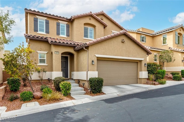 mediterranean / spanish house with driveway, a tile roof, and stucco siding